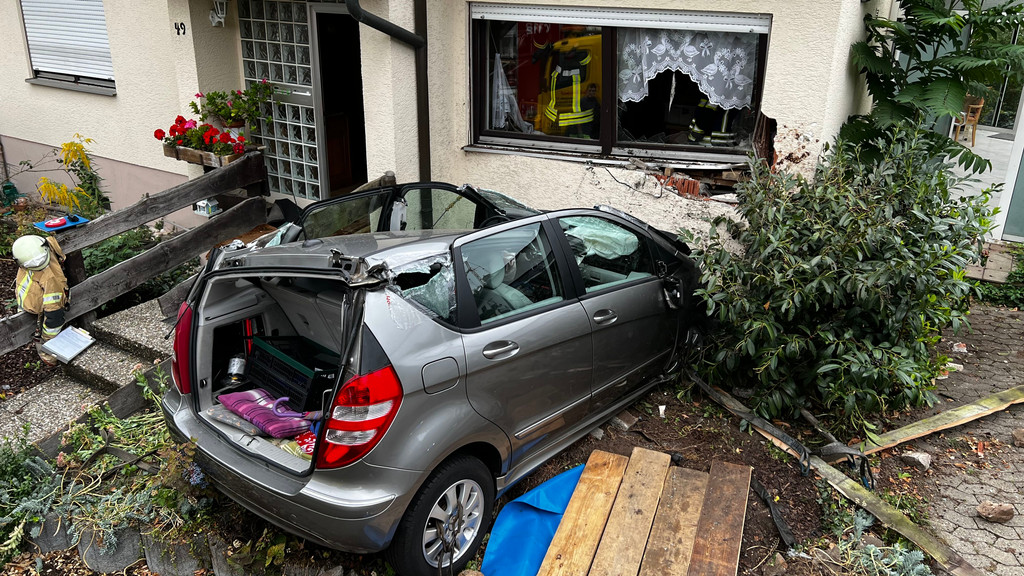 Ein durch einen Unfall beschädigtes Auto steht im Vorgarten eines Hauses. 