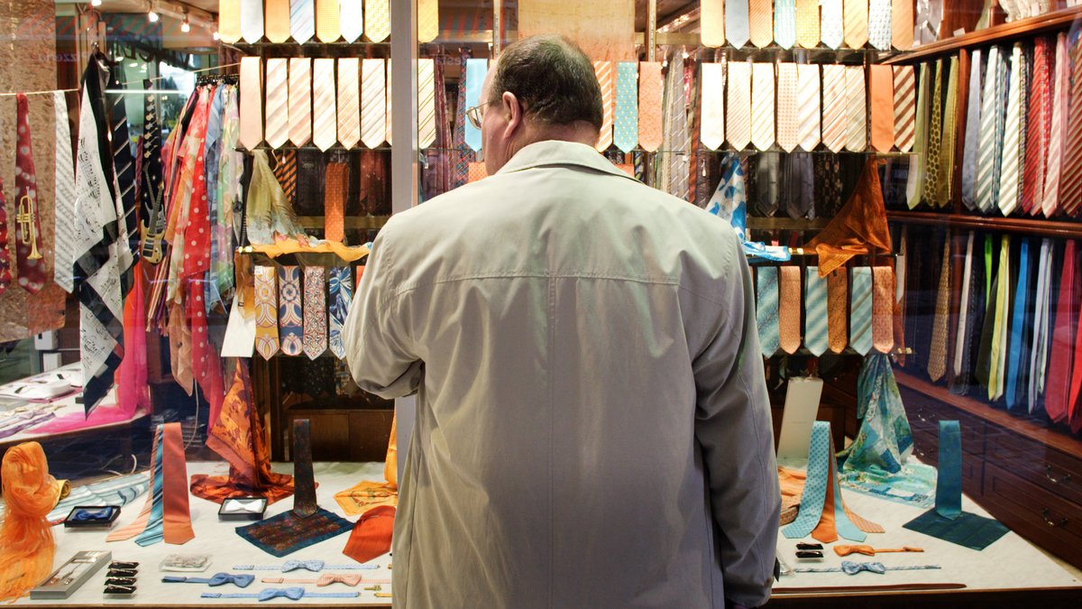 Mann vor einem Schaufenster eines Krawattenladens