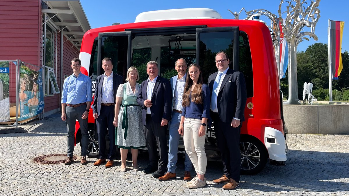Verkehrsminister Bernreiter (Mitte) mit Bad Birnbachs Bürgermeisterin Feicht und anderen Gästen vor einem Elektrobus in Bad Birnbach