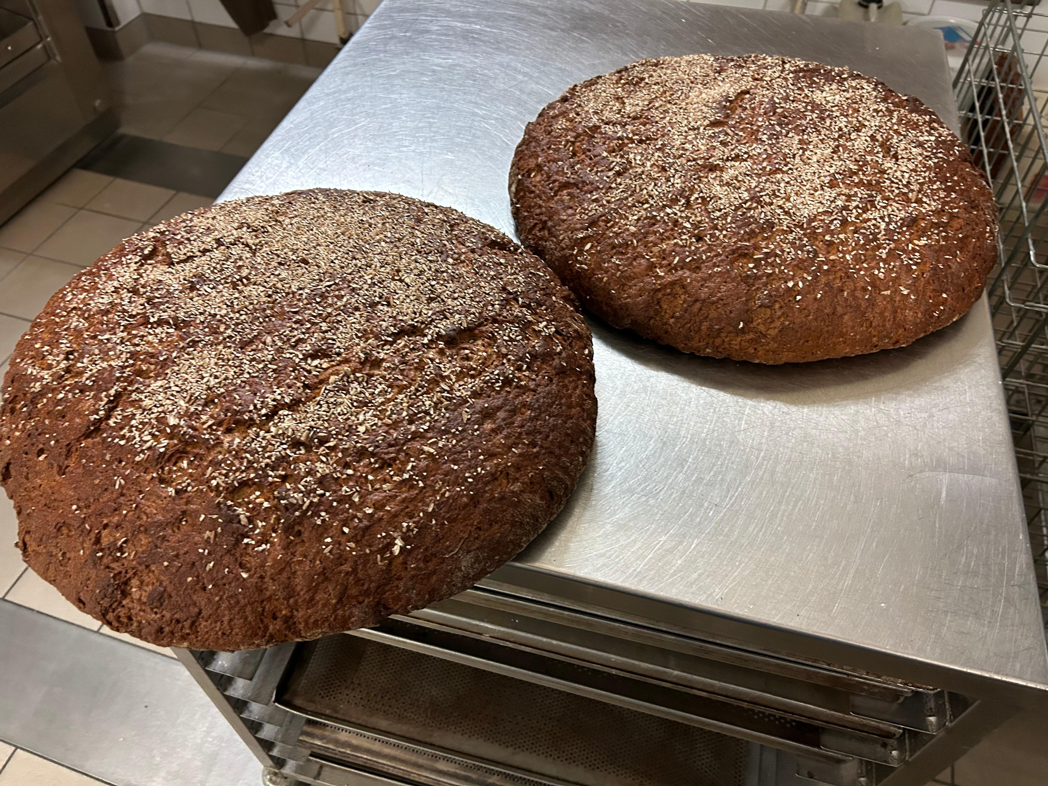 Zwei Laibe Brot liegen auf einem Tisch.