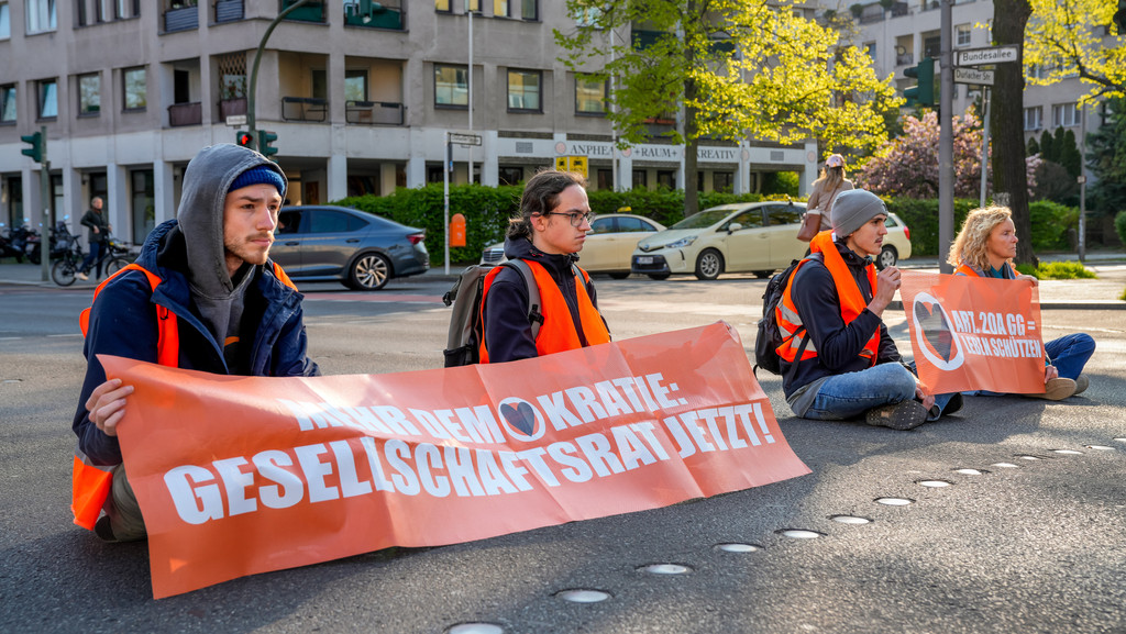 Die Aktivisten der Gruppe Letzte Generation bei einer Blockade-Aktion in der Bundesallee im Bezirk Tempelhof-Schöneberg