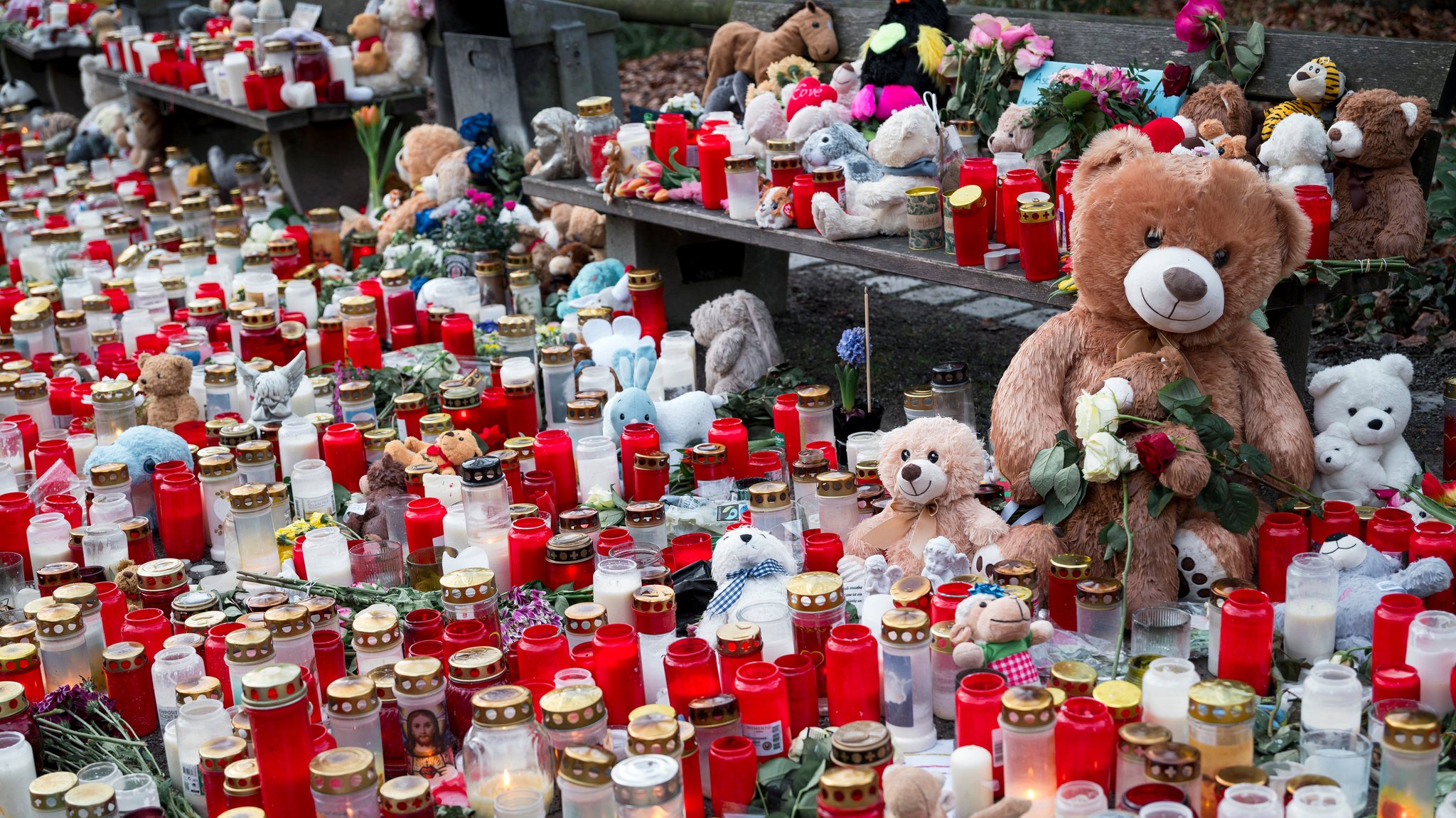 Zahlreiche Kerzen und Blumen liegen zum Gedenken an die Opfer des tödlichen Messerangriffs im Park Schöntal am Boden.