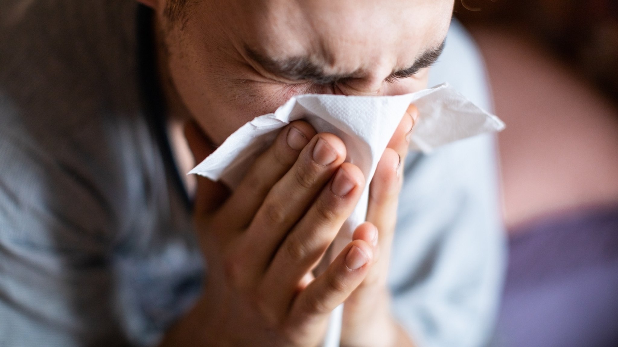 A man's face is cut with a handkerchief in front of his nose