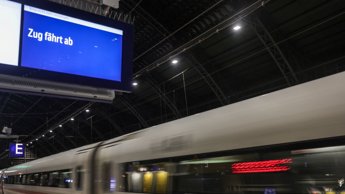 "Zug fährt ab" steht auf einer Anzeigetafel am Bahnsteig während ein ICE den Hauptbahnhof Köln verlässt.