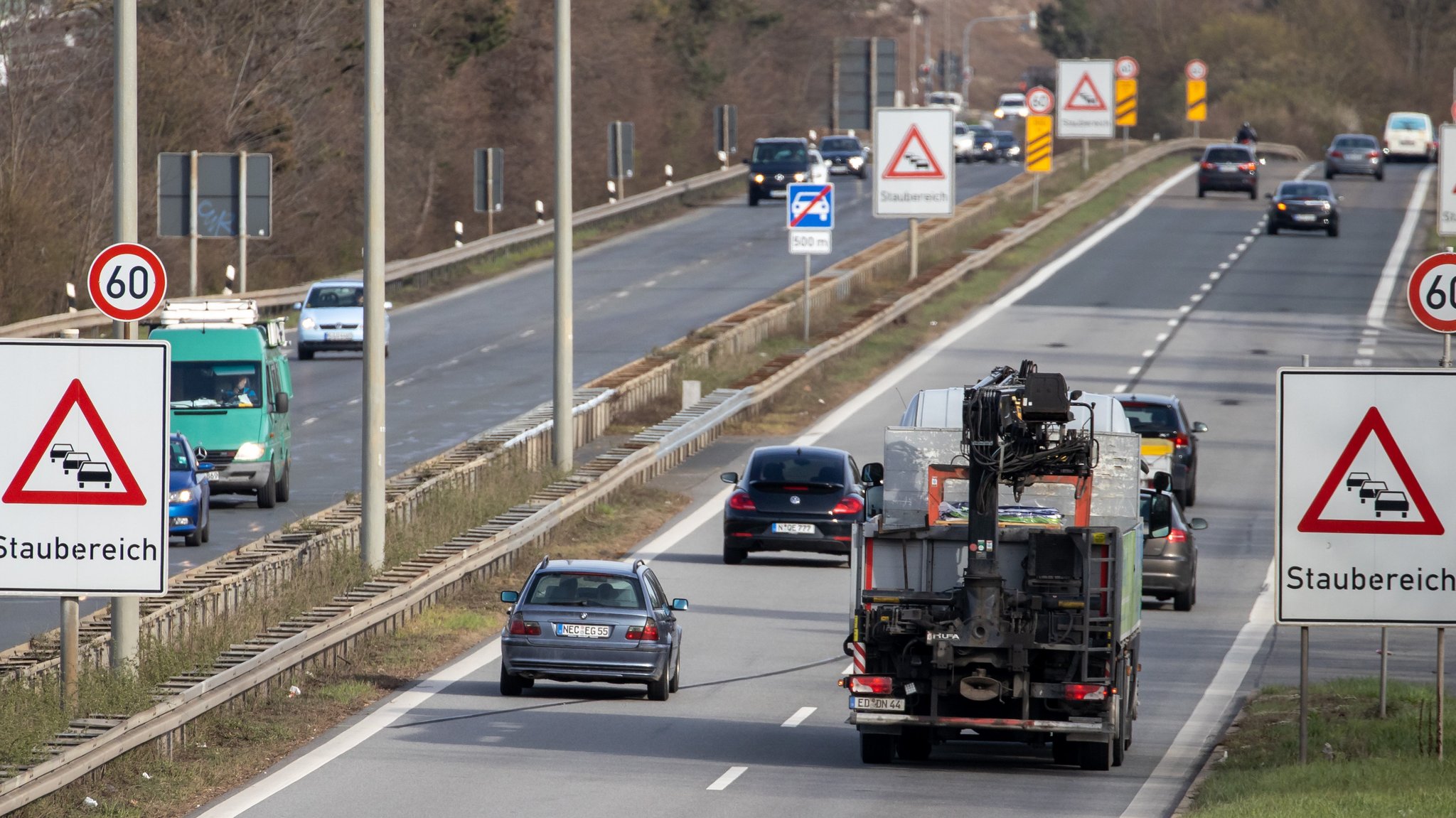 Autos und Lkw auf dem Frankenschnellweg, am Straßenrand warnen Schilder vor Stau.