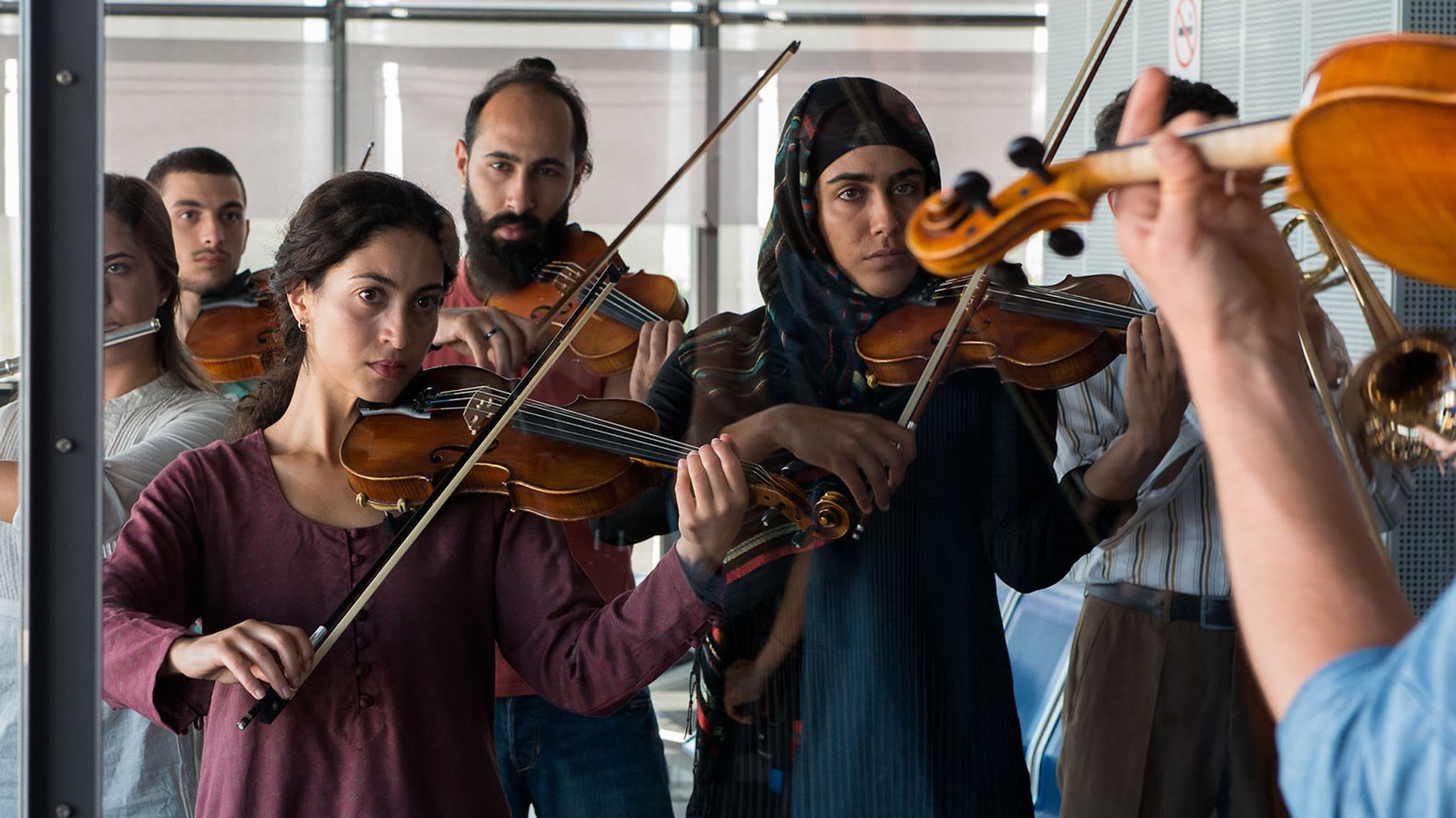 Junge Geigerinnen und Geiger spielen konzentriert zusammen (Filmsezene aus "Crescendo  #Makemusicnotwar")