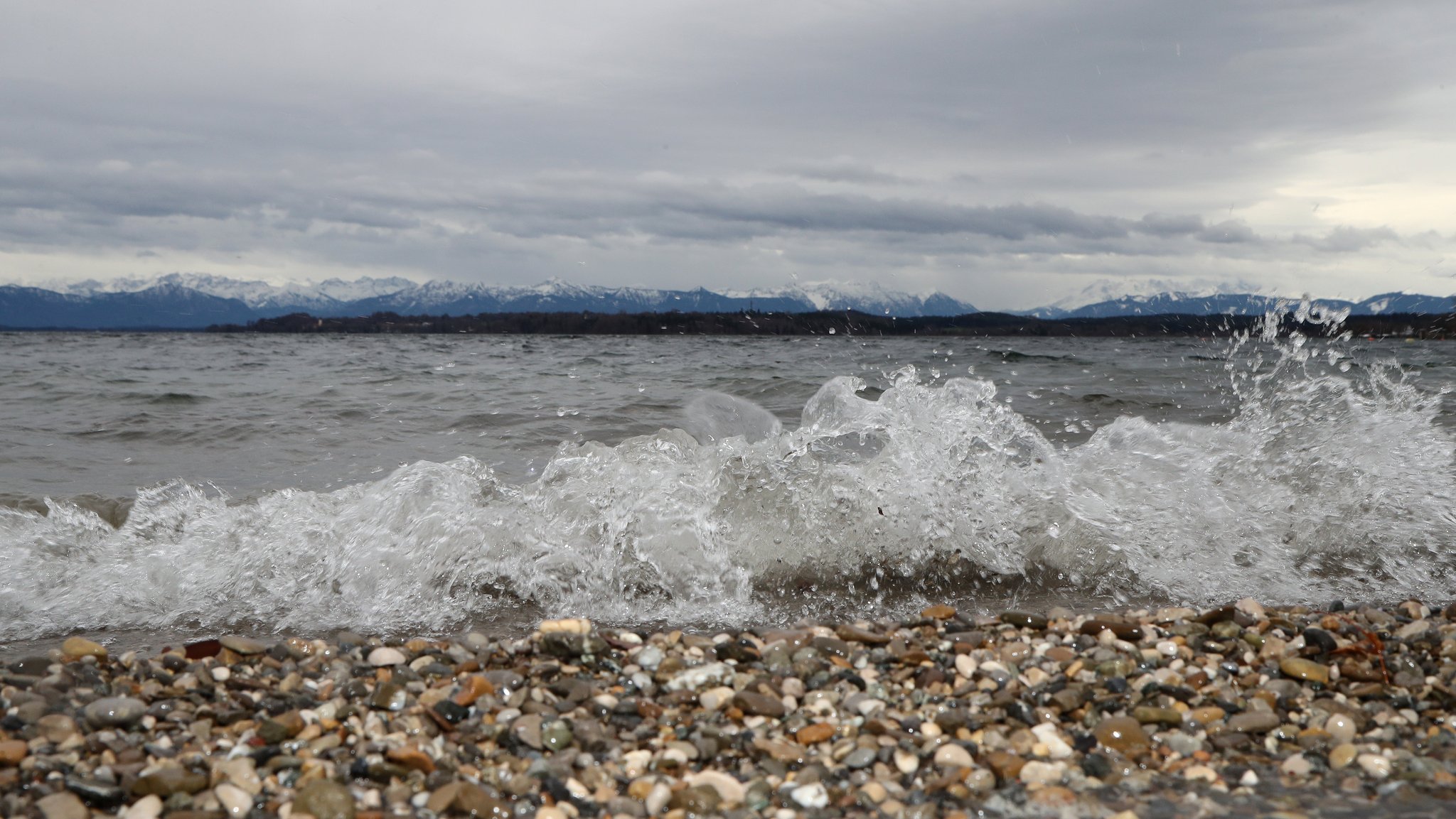 Tutzing, Bayern, Deutschland 21. Dezember 2023: Ein Wintertag in Tutzing (Landkreis Starnberg). Hier der Blick von der Brahmspromenade auf den Starnberger See bei stürmischem Wind, windig, Orkan, Wolken, trüb, Wetterbild, stürmisch, Wellen, Wellengang, Gischt, Ufer, Wasserspritzen, Wucht, Naturgewalt, Wassermassen