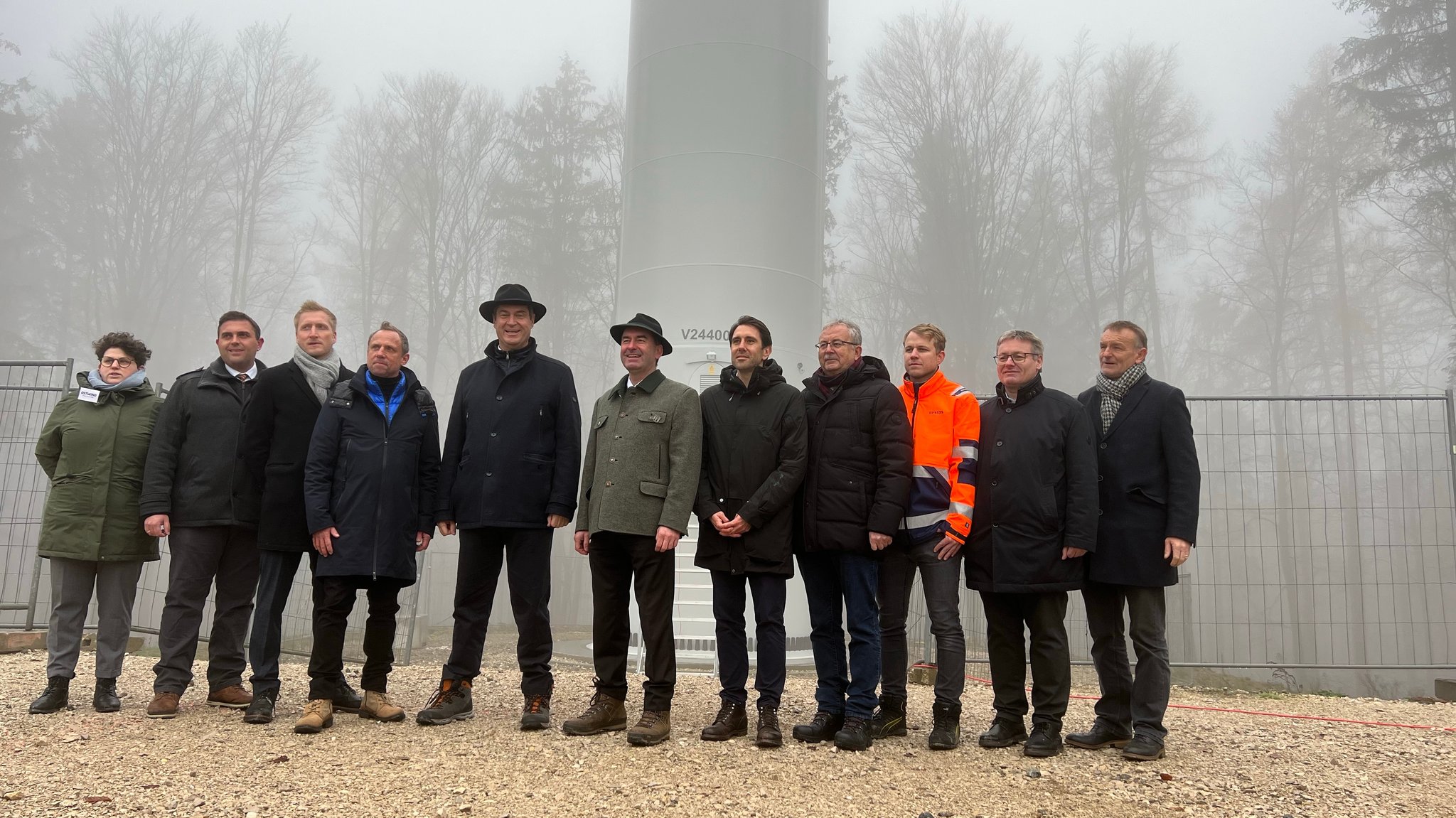 Mehrere Menschen, darunter Ministerpräsident Markus Söder und Wirtschaftsminister Hubert Aiwanger, stehen vor einem Windrad.