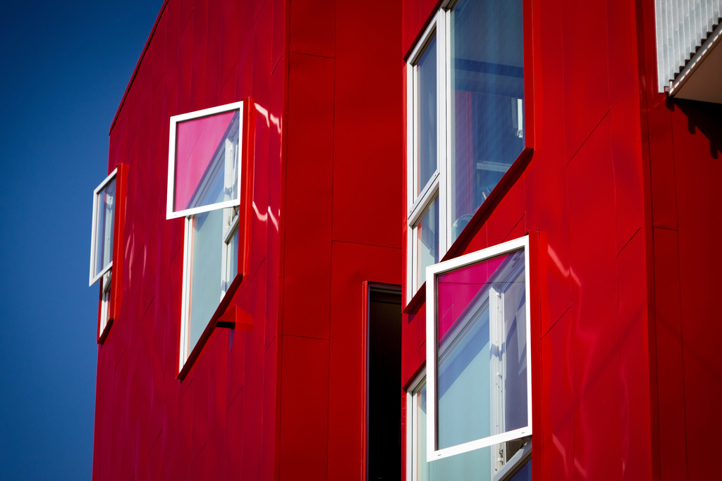 Rotes modernes Gebäude mit offenen Fenstern.