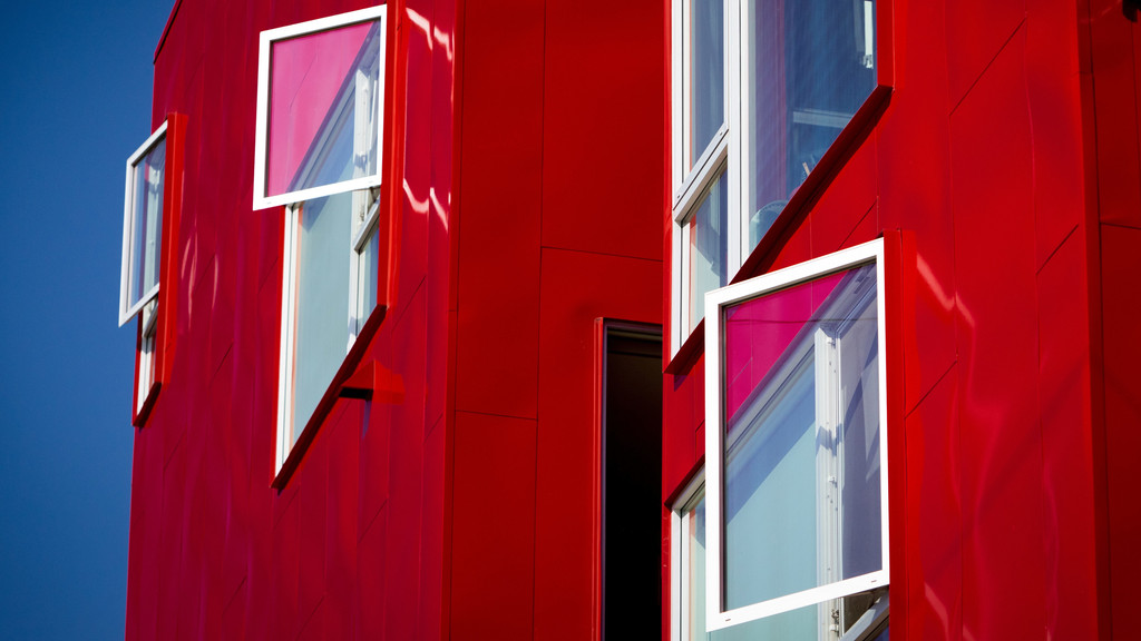Rotes modernes Gebäude mit offenen Fenstern.