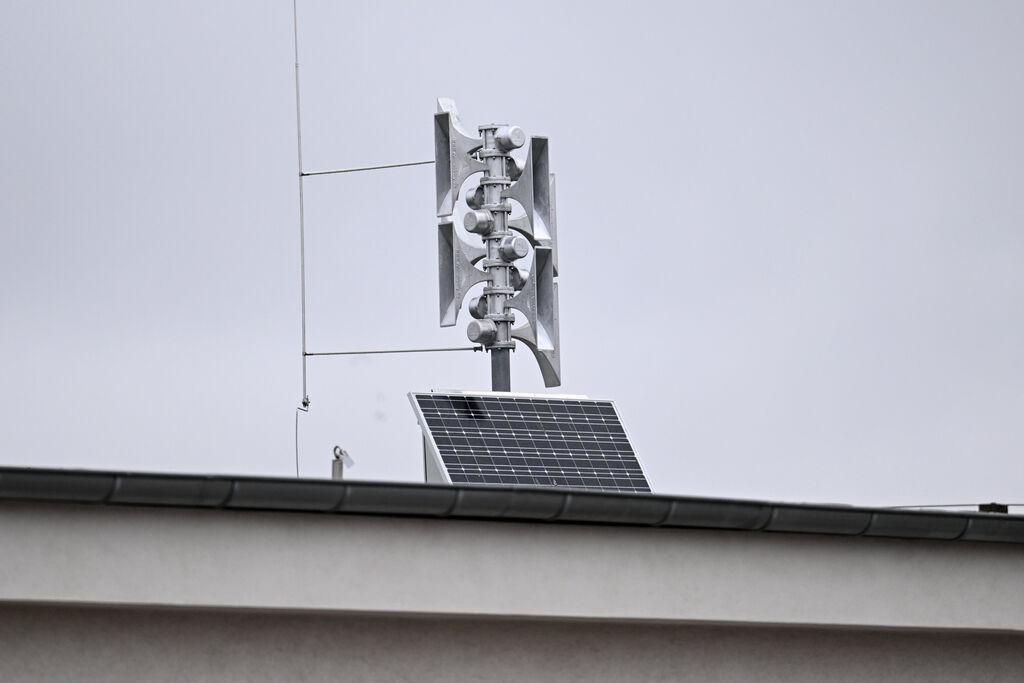 Eine moderne Sirene mit PV-Modul auf einem Dach.