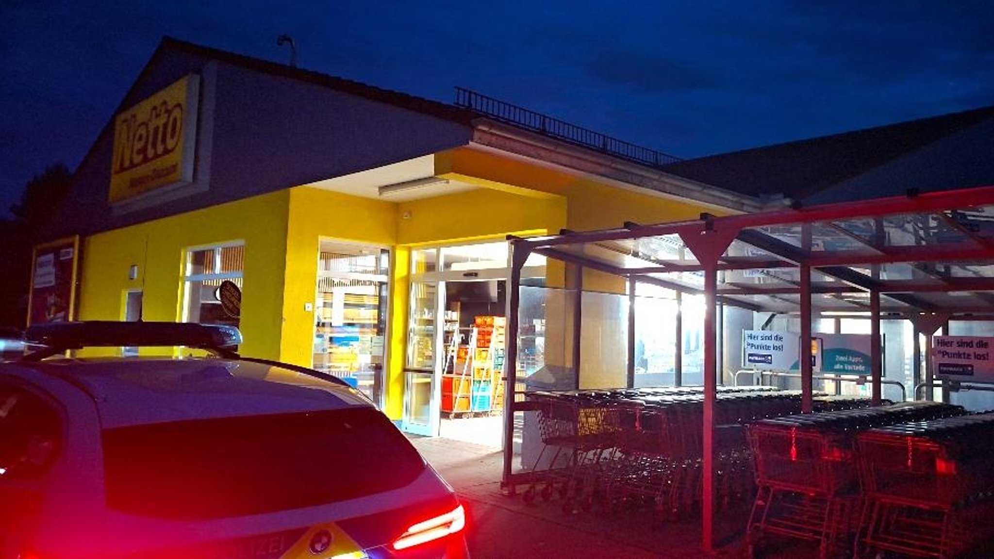 Polizeiwagen vor einem Supermarkt
