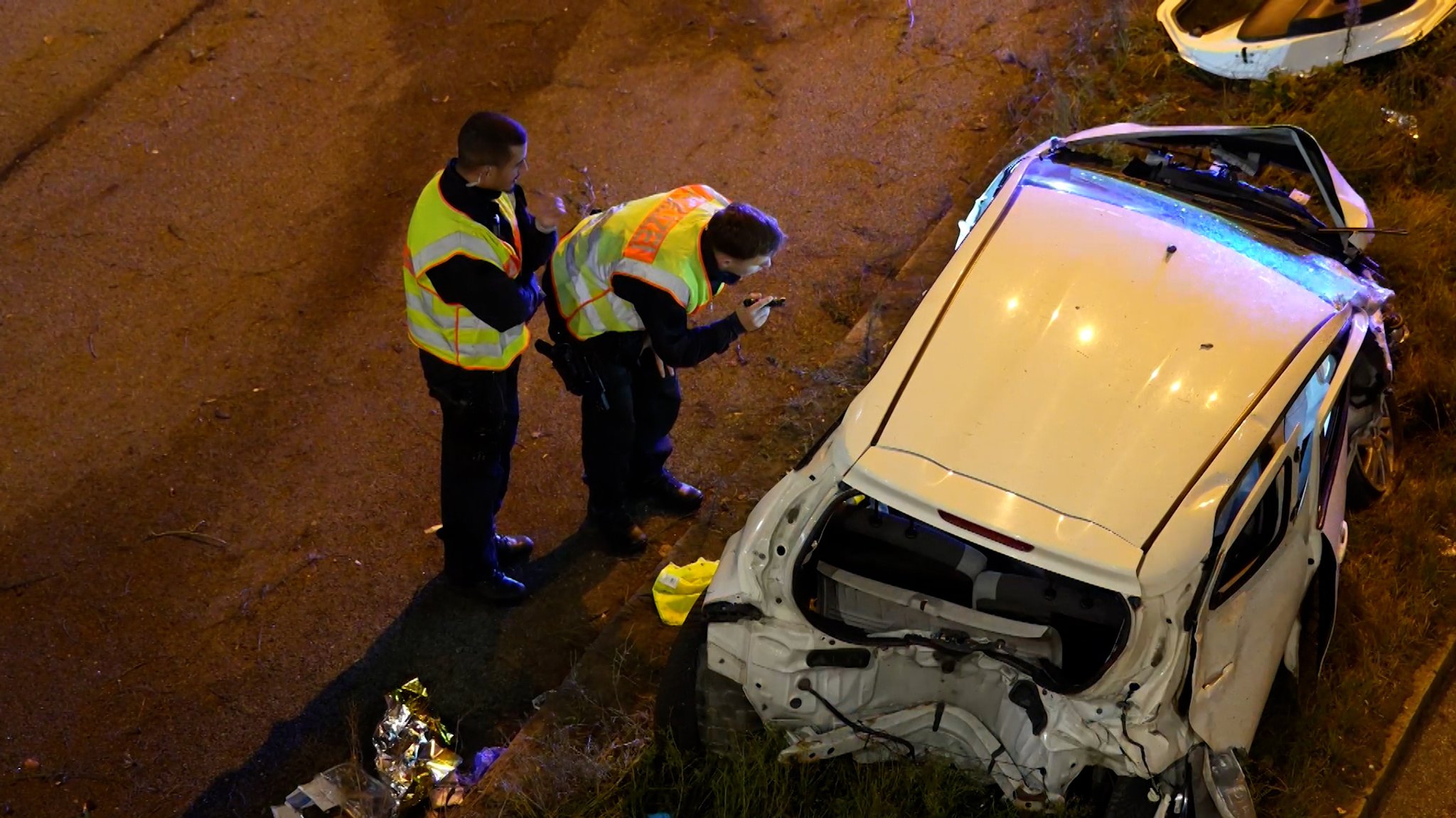 Zwei Polizisten in Warnwesten inspizieren ein verunfalltes Auto | Bild: Bayerischer Rundfunk 2025 Zwei Polizisten in Warnwesten inspizieren ein verunfalltes Auto