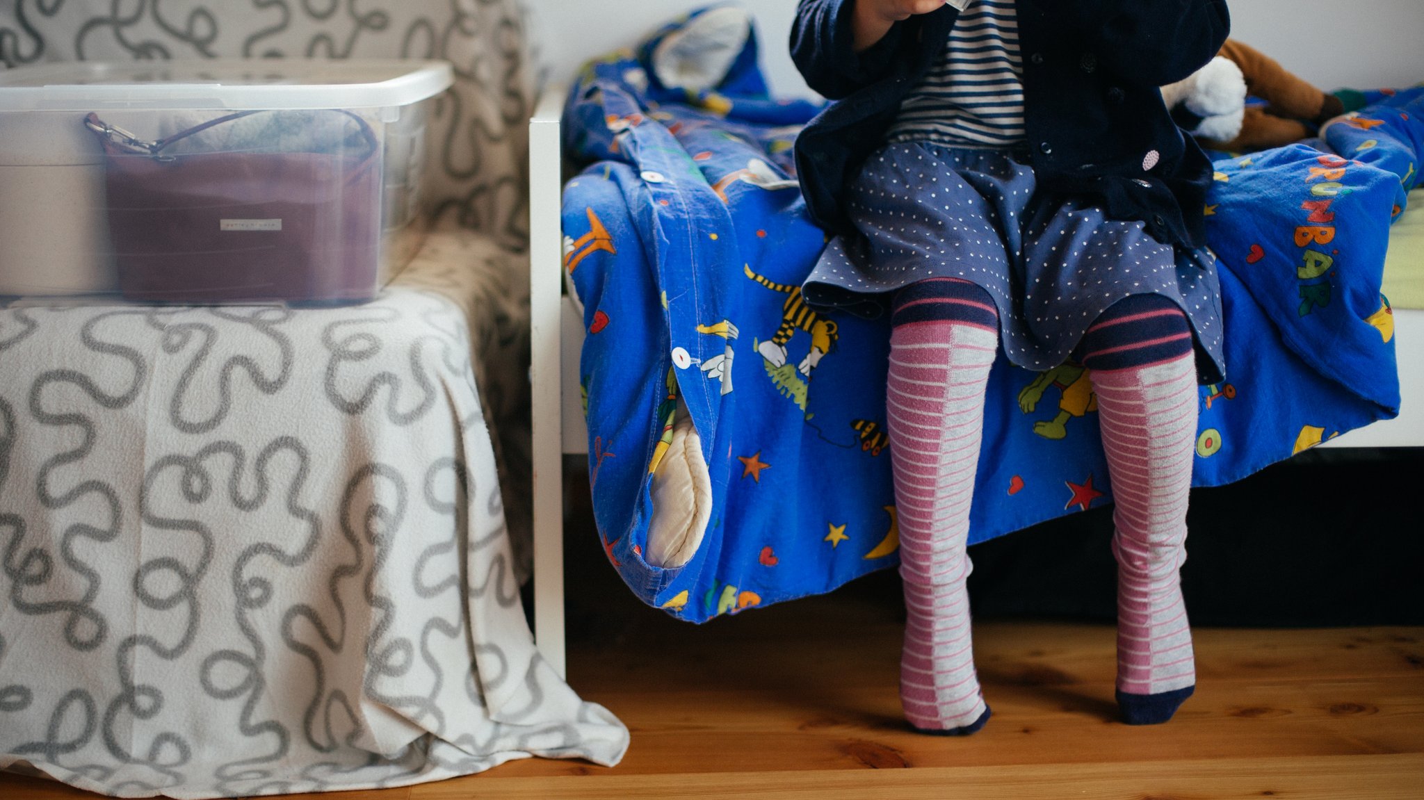 Ein Kind sitzt im Kinderzimmer auf dem Bett (Symbolbild)