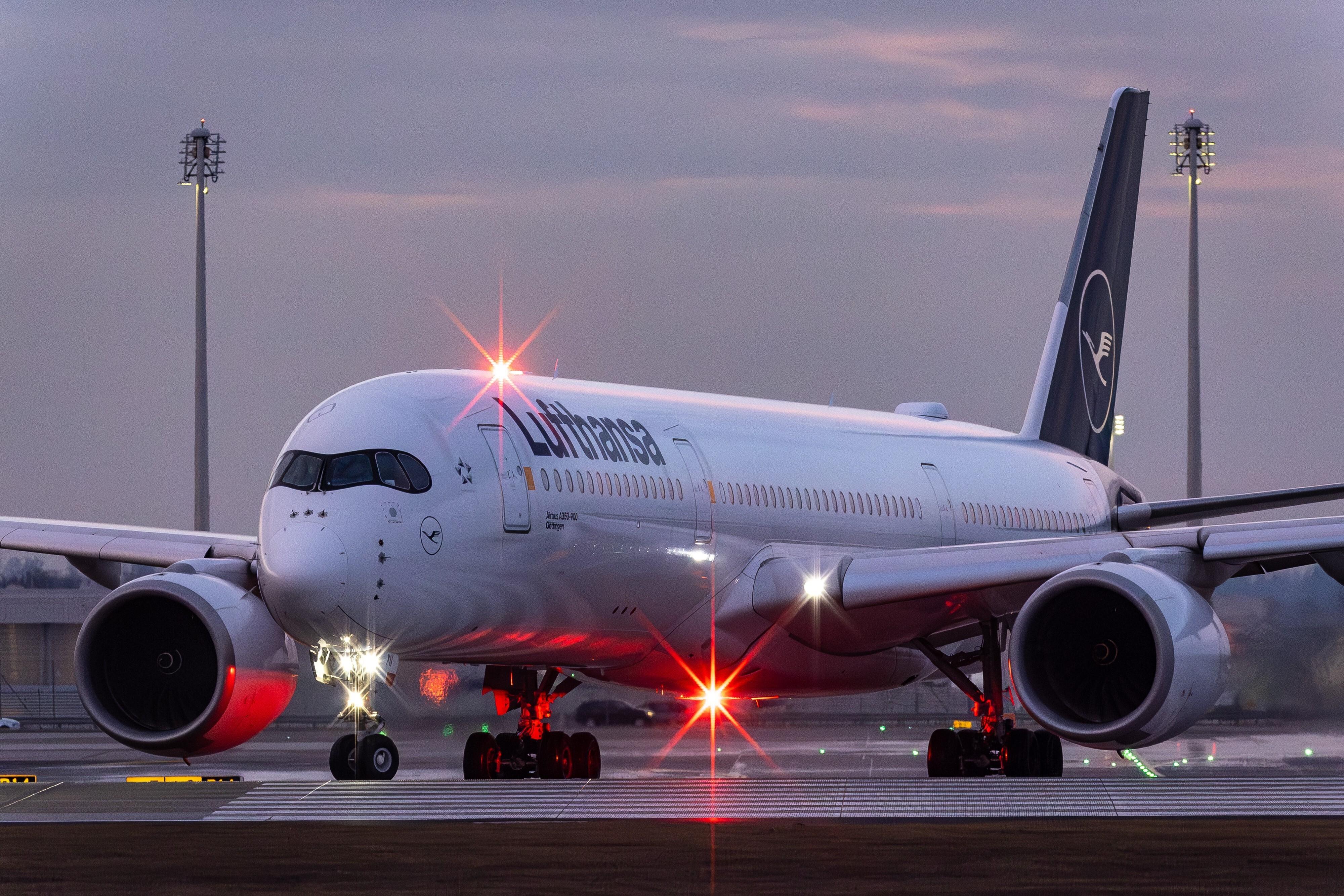 Eine Maschine von Lufthansa steht am Flughafen München, unter dem Flugzeug leuchtet eine rote Lampe. (Symbolbild)