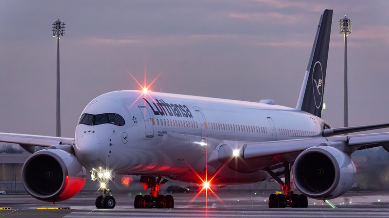 Eine Maschine von Lufthansa steht am Flughafen München, unter dem Flugzeug leuchtet eine rote Lampe. (Symbolbild) | Bild: picture alliance / kolbert-press/Martin Agüera Eine Maschine von Lufthansa steht am Flughafen München, unter dem Flugzeug leuchtet eine rote Lampe. (Symbolbild)
