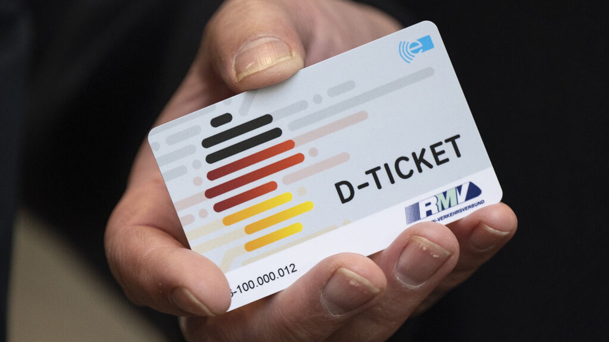 Eine Person hält ein Deutschlandticket in der Hand. 