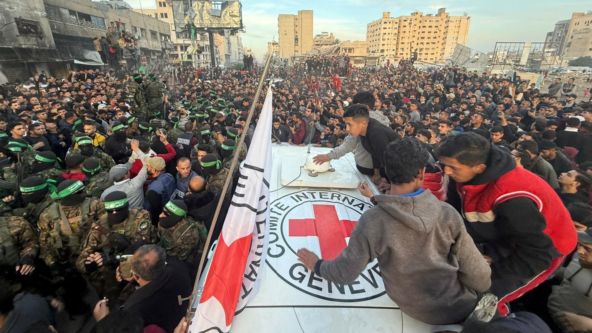 Hamas-Mitglieder an einem Rotkreuz-Wagen kurz vor der Freilassung der ersten drei Geiseln.