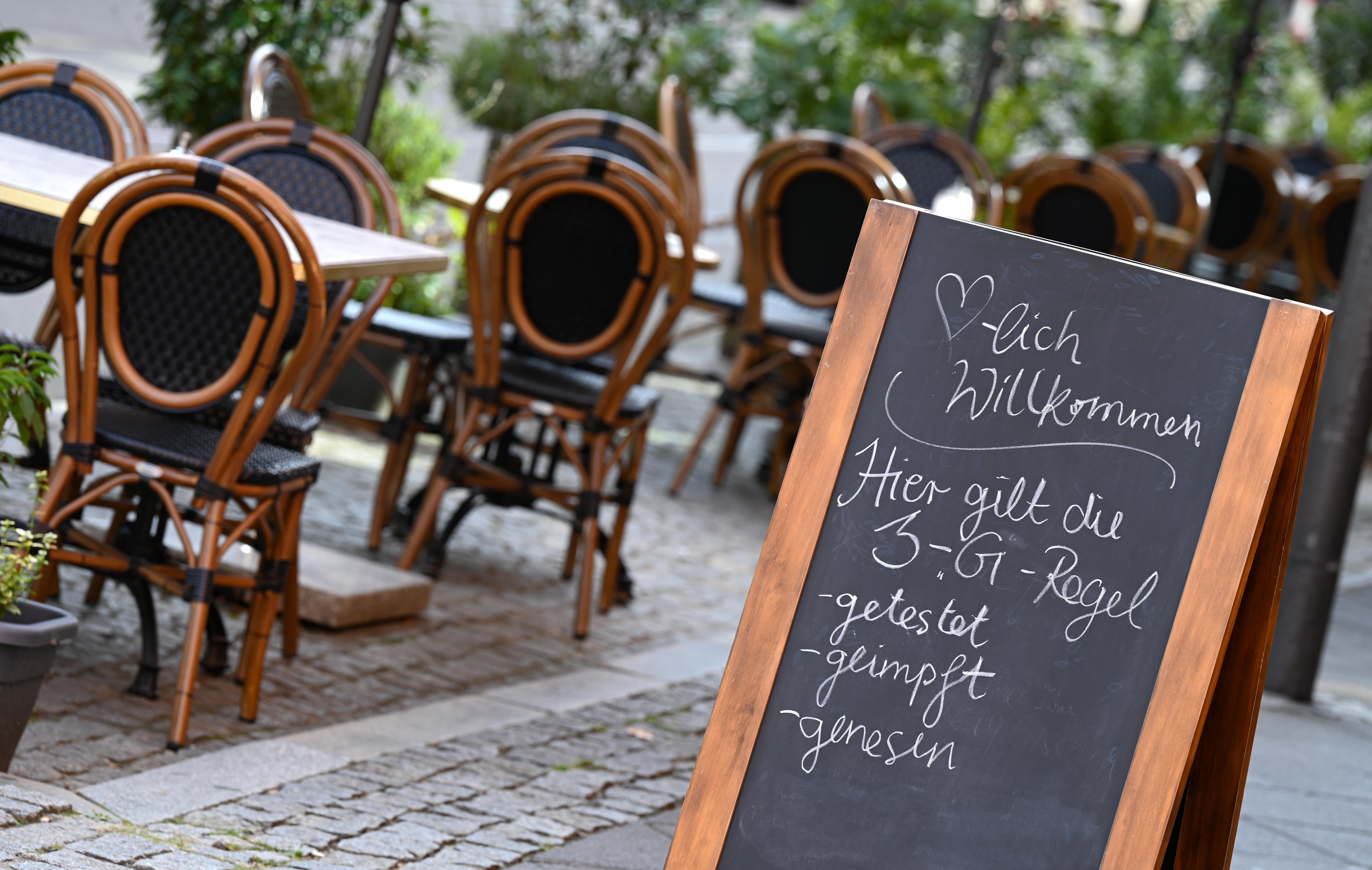 Tafel mit der Aufschrift "Herzlich Willkommen. Hier gilt die 3-G-Regel - getestet -geimpft - genesen" vor einem Cafe | Bild:pa/dpa/Arne Dedert