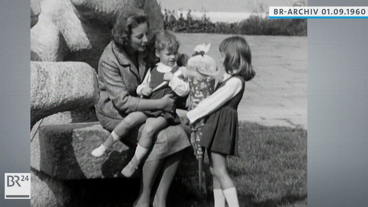 Ruth Kappelsberger mit einem kleinen Mädchen auf dem Schoß, daneben eine  Erstklässlerin mit Schultüte