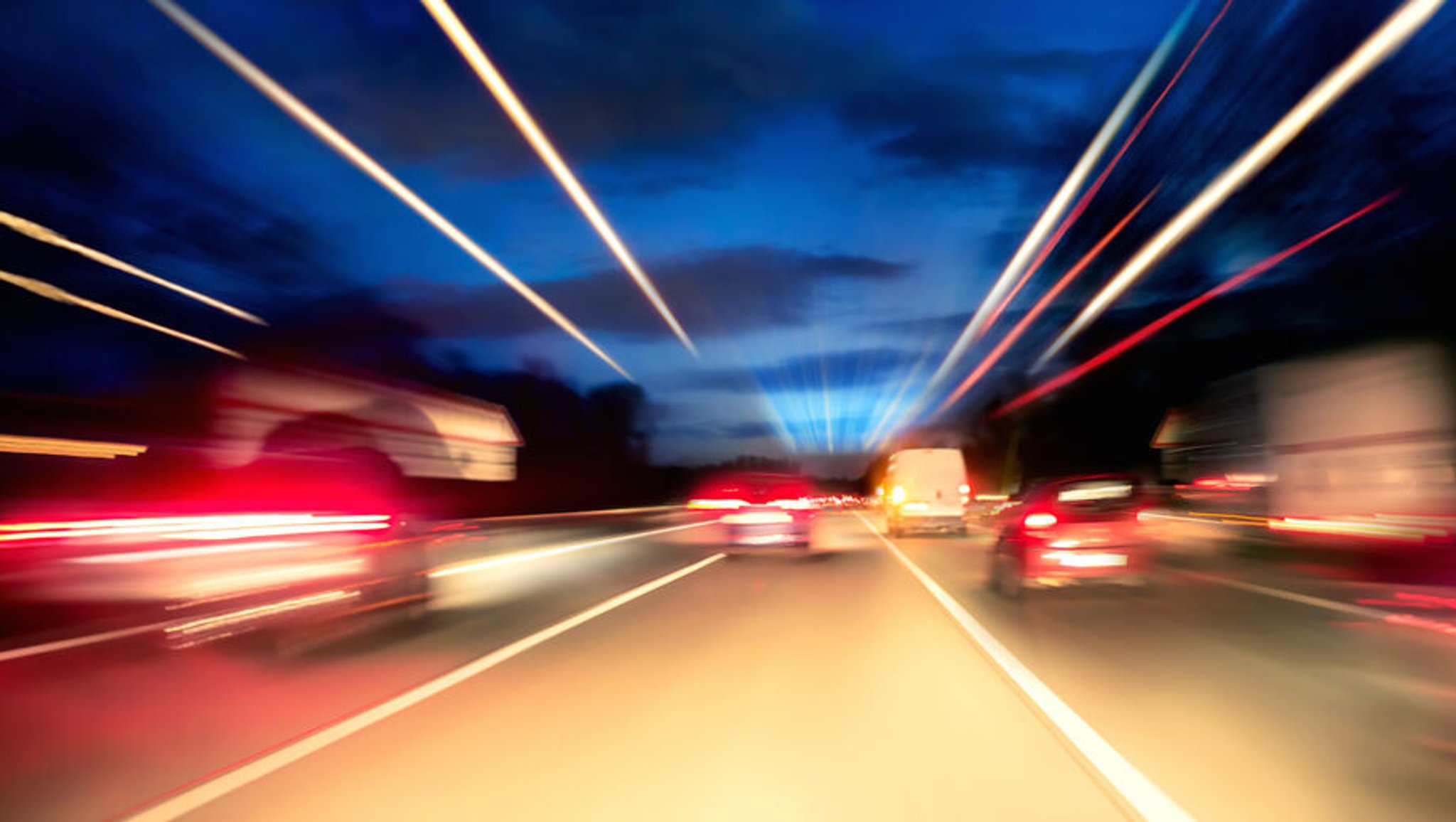 Autos auf der nächtlichen Autobahn mit Lichtspuren. 