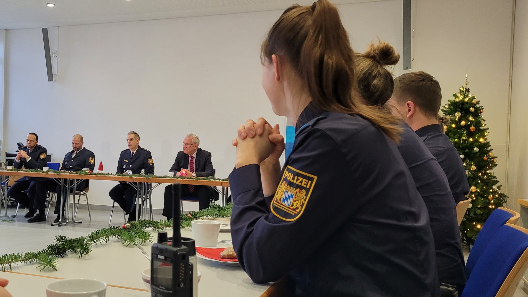 Dienststellenleiter in Erlangen, Polizeidirektor Klaus Wild (3.v.l.) und Innenminister Joachim Herrmann in einem Besprechungszimmer, im Vordergrund Polizistinnen und Polizisten in Uniform