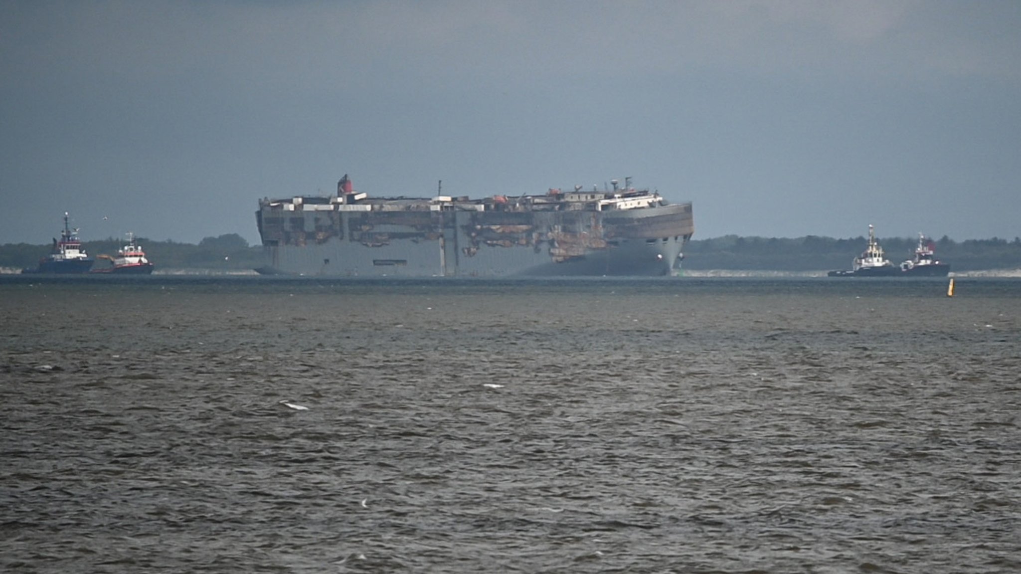 Der Autofrachter "Fremantle Highway" wird von zwei Booten auf der Außenems vor Borkum geschleppt. 