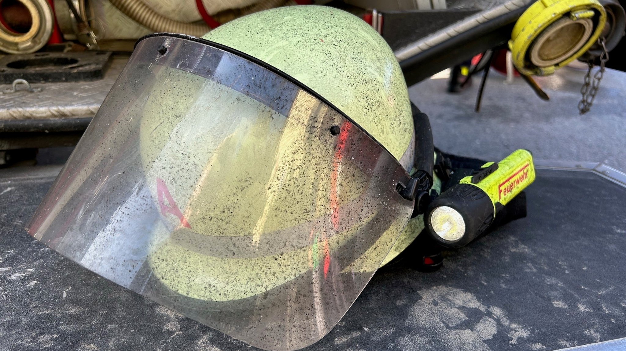 Ein Feuerwehrhelm an dem Rußpartikel zu sehen sind. 