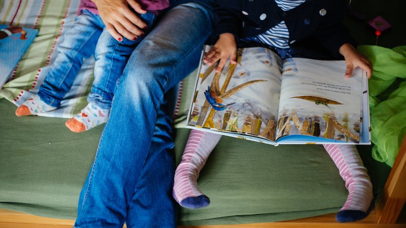 Eine Mutter liest ihren Kindern aus einem Bilderbuch vor. | Bild: BR/Julia Müller Eine Mutter liest ihren Kindern aus einem Bilderbuch vor.