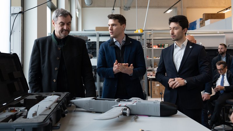 Bayerns Ministerpräsident Markus Söder steht mit zwei Unternehmern an einem Tisch und blickt auf eine Drohne. | Bild: TYTAN Technologies GmbH Bayerns Ministerpräsident Markus Söder steht mit zwei Unternehmern an einem Tisch und blickt auf eine Drohne.
