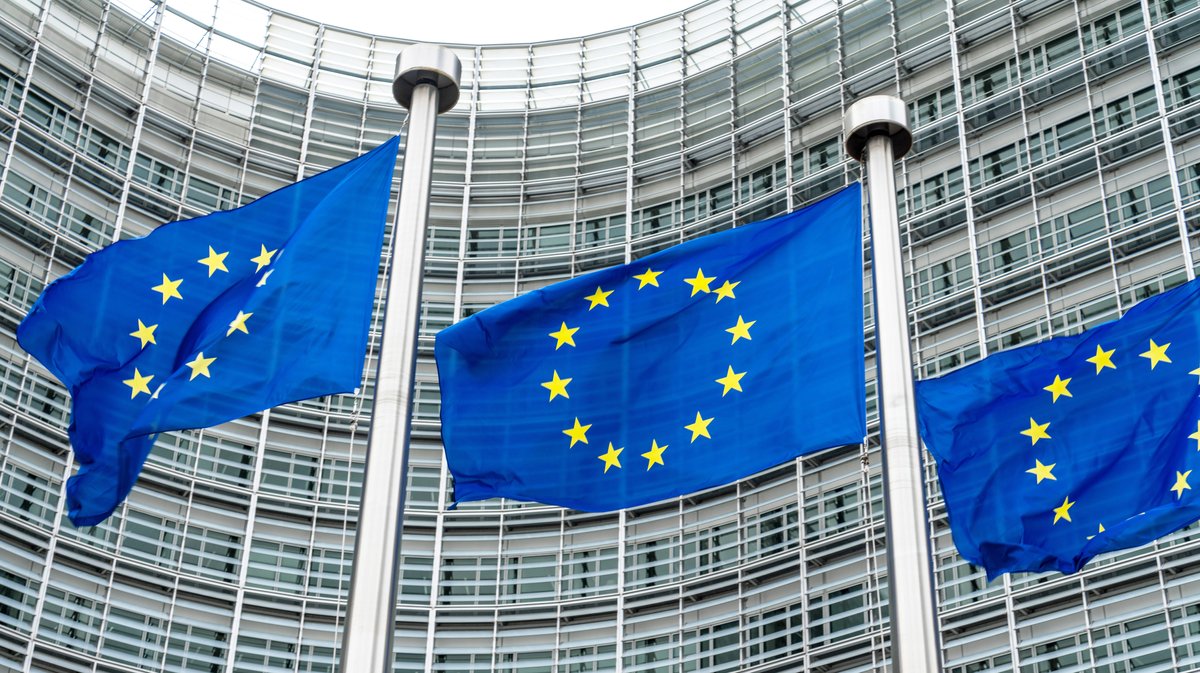 EU-Falggen vor dem Sitz der EU-Kommission in Brüssel gibt erste eingefrorene Zinserlöse aus Russen-Vermögen für Ukraine frei