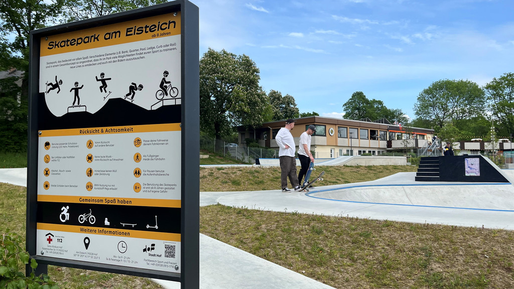 Ein Schild mit der Aufschrift "Skatepark am Eisteich" - im Hintergrund stehen zwei Skateboarder. | Bild: BR / Annerose Zuber Ein Schild mit der Aufschrift "Skatepark am Eisteich" - im Hintergrund stehen zwei Skateboarder.