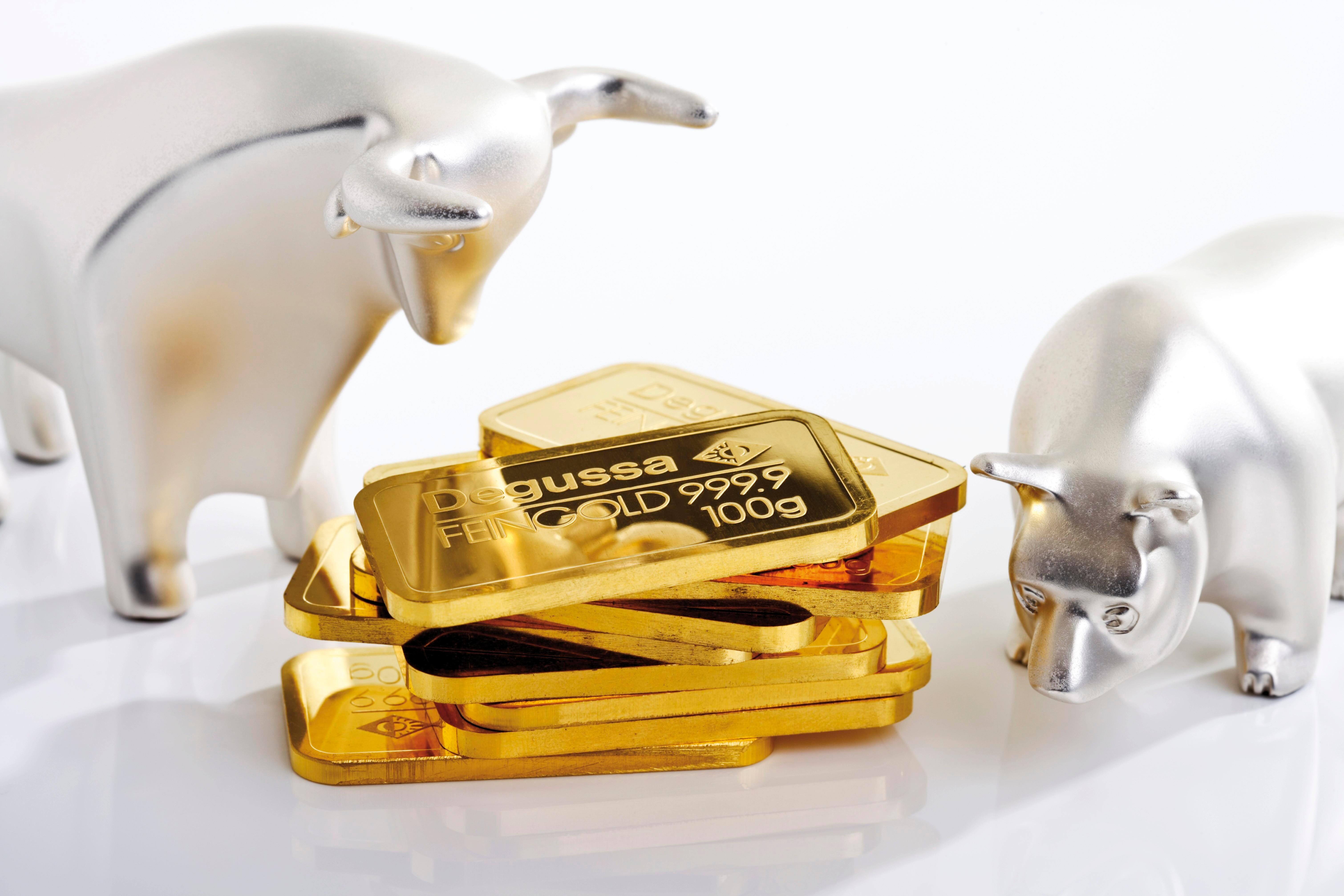 Ein Bär neben Goldunzen. Der Bär an der Börse steht symbolisch für fallende Kurse.