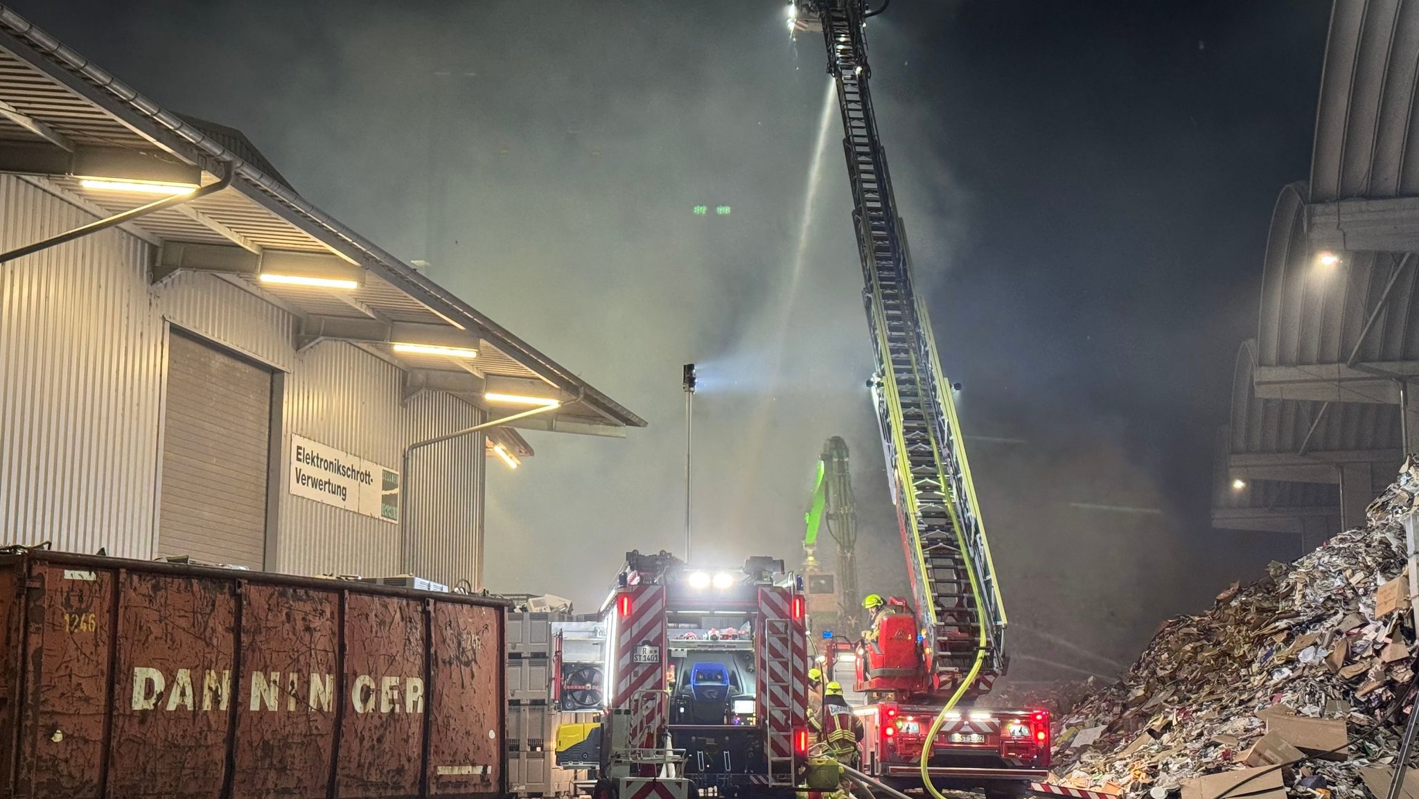 Einsatzkräfte der Feuerwehr kämpfen gegen den Brand in einer Recyclinganlage in Regensburg.