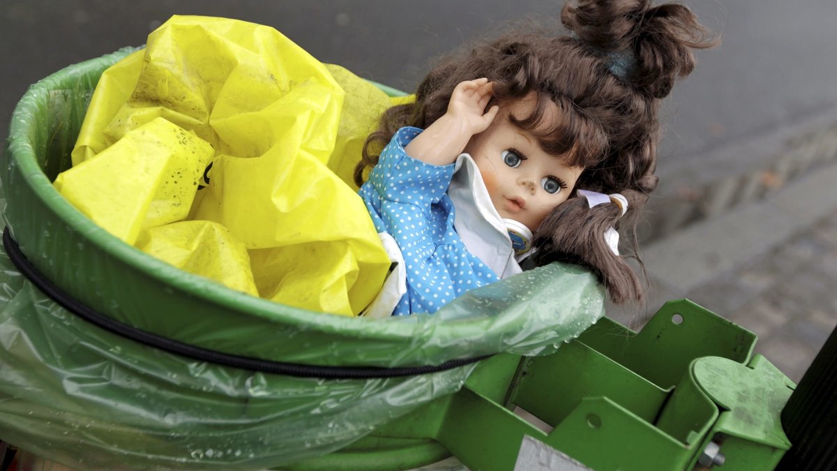 Puppe im Mülleimer