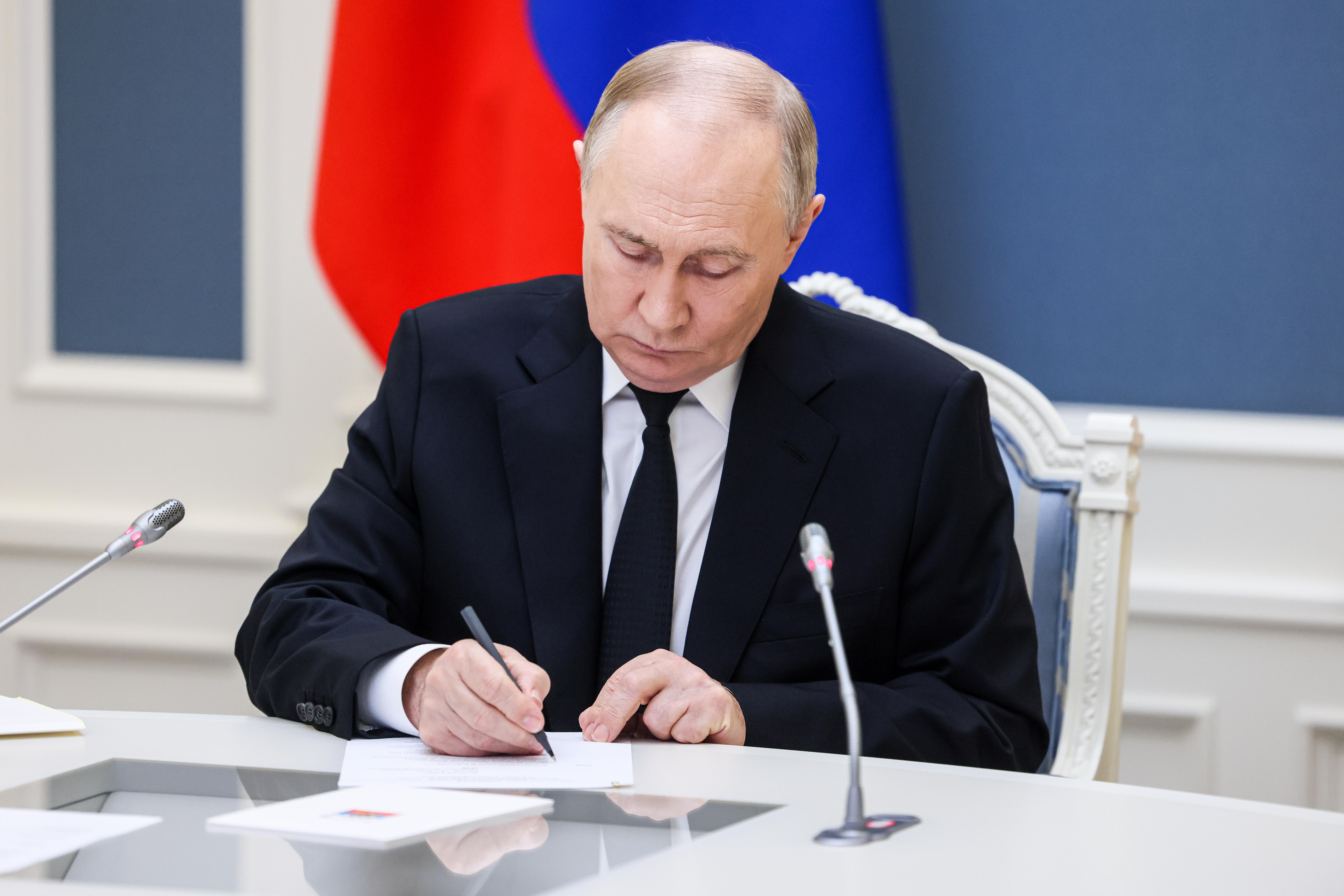 Der russische Präsident schreibt etwas auf ein Blatt