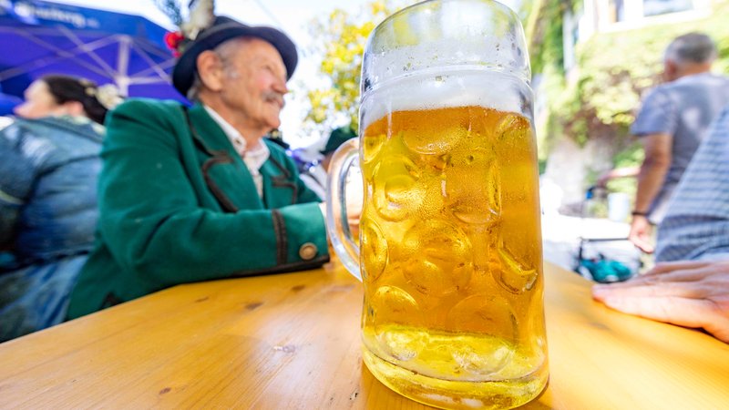Vor einem Mann in Tracht steht ein Masskrug mit Bier | Bild: picture alliance Vor einem Mann in Tracht steht ein Masskrug mit Bier