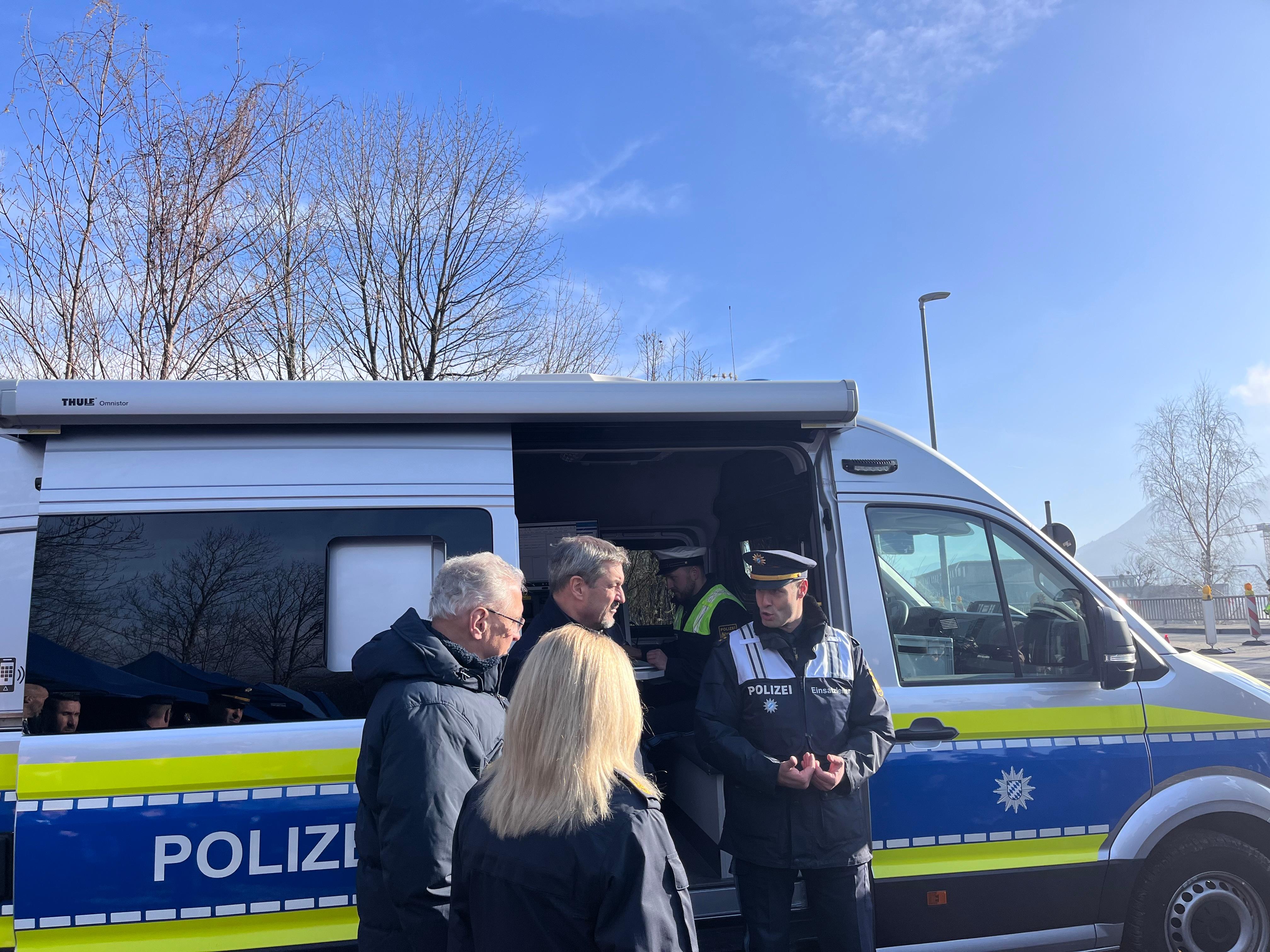 Ein Polizeiauto, davor Ministerpräsident Dr. Markus Söder und Innenminister Joachim Herrmann mit Polizisten