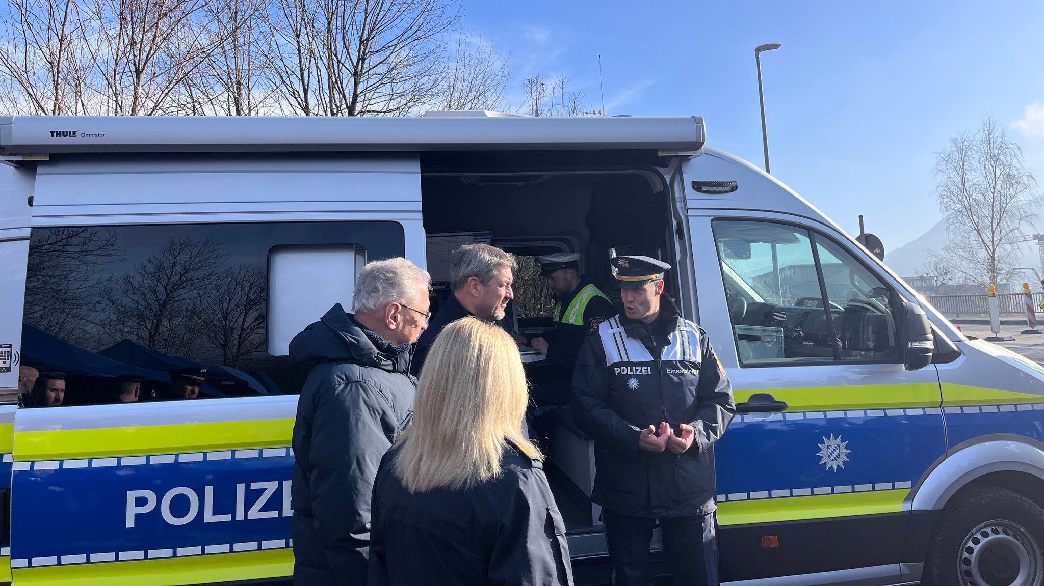 Ein Polizeiauto, davor Ministerpräsident Dr. Markus Söder und Innenminister Joachim Herrmann mit Polizisten