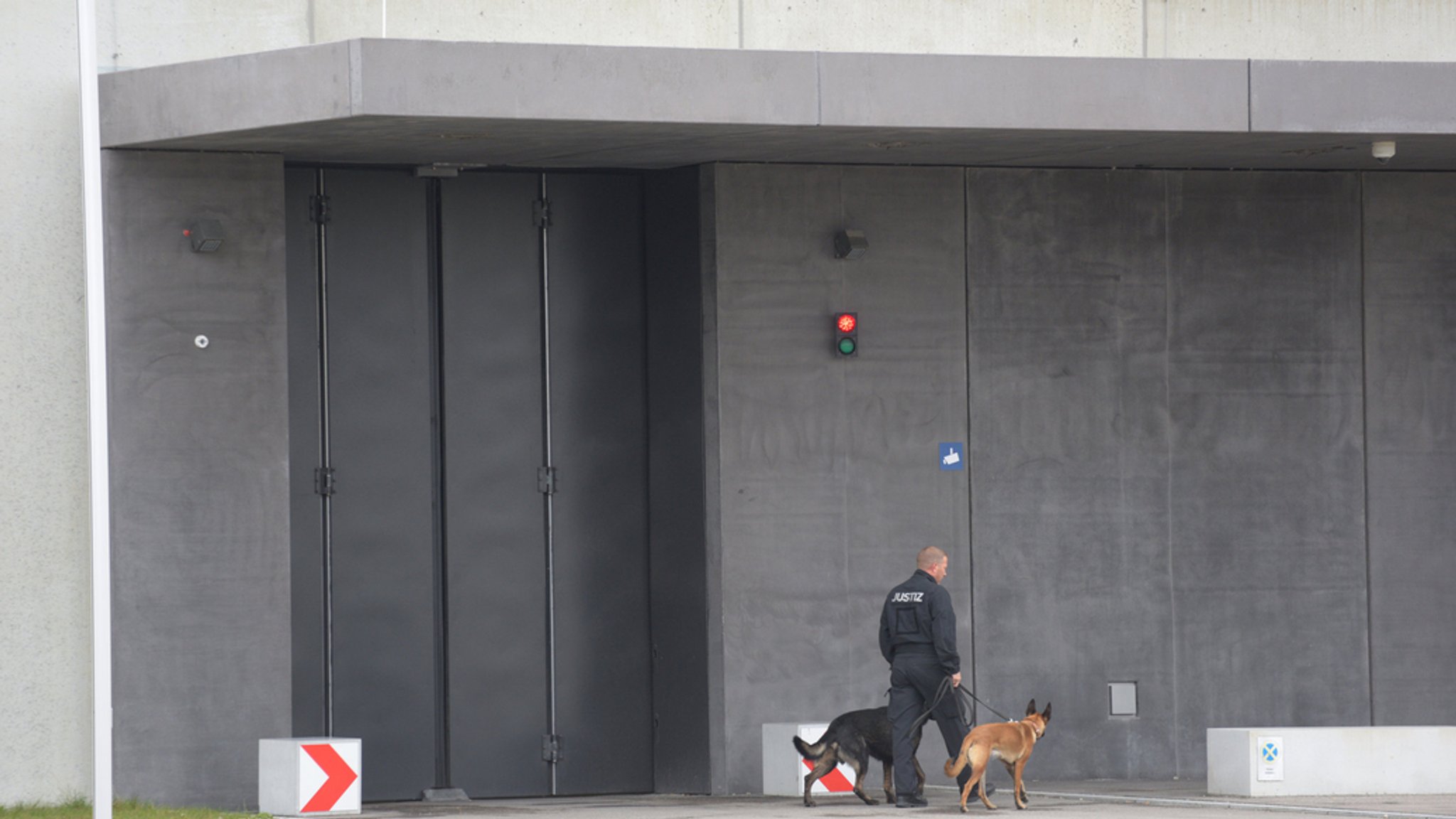 Ein Justizangehöriger geht mit zwei Hunden vor der Justizvollzugsanstalt Augsburg-Gablingen (Archivbild von 2018).