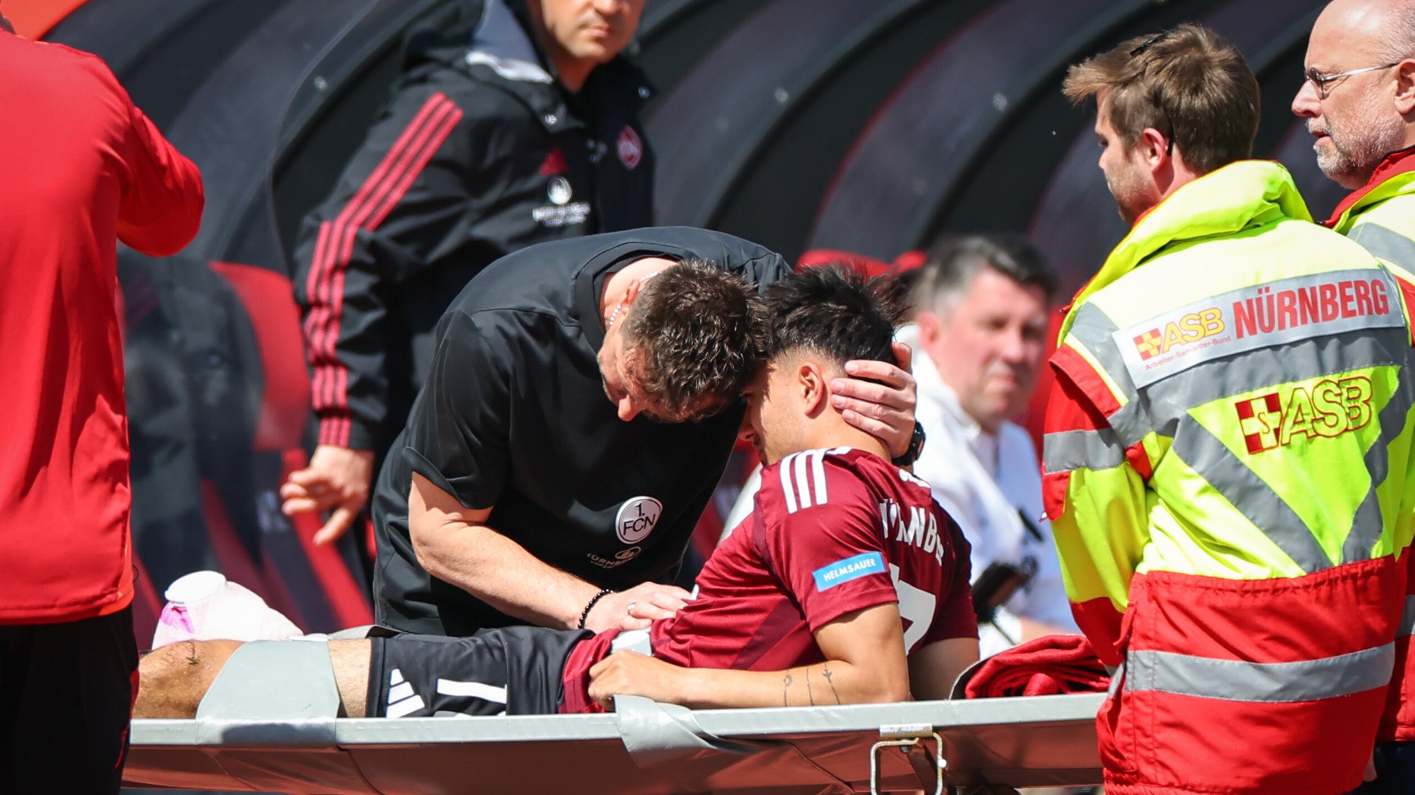 Der Nürnberger Trainer Miroslav Klose (l) steht neben seinem Spieler Jens Castrop (M) der verletzt vom Platz getragen wird.