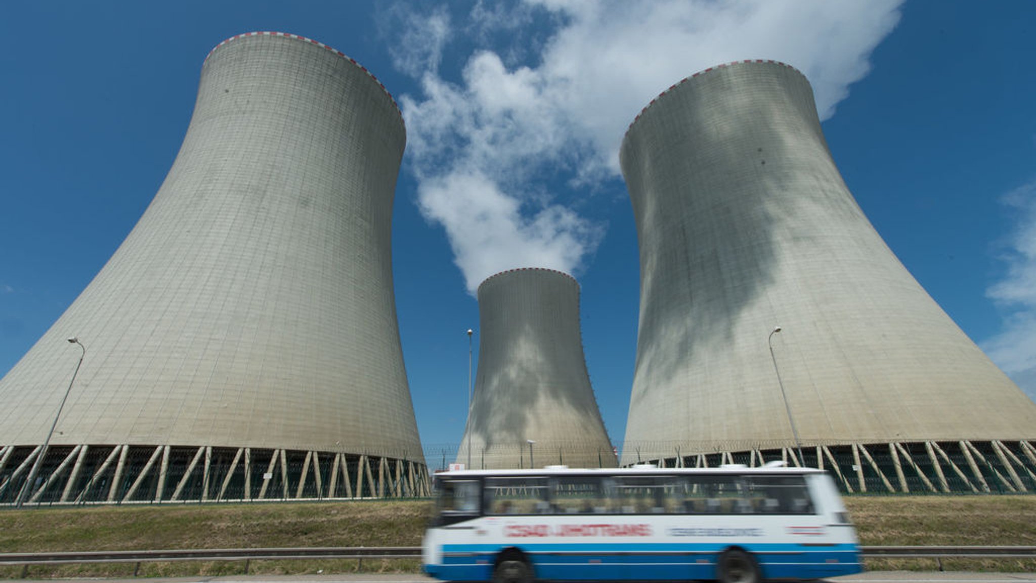 ARCHIV - 22.06.2012, Tschechien, Temelín: Ein Bus fährt vor den Kühltürmen des Atomkraftwerks Temelin in Tschechien entlang. Temelin ist weniger als 60 Kilometer von der Grenze zu Bayern entfernt. (zu dpa: «Reaktorblock in tschechischem AKW abgeschaltet») Foto: Armin Weigel/dpa +++ dpa-Bildfunk +++