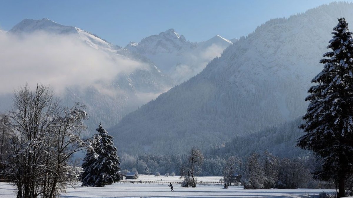 09.01.2024, Bayern, Oberstdorf: Ein Langläufer durchstreift die schneebedeckte Berglandschaft im Sonnenschein. Foto: Karl-Josef Hildenbrand/dpa +++ dpa-Bildfunk +++