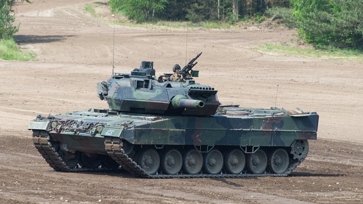 Ein Kampfpanzer Leopard 2 fährt auf einem Übungsfeld.