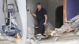 Mann steht in zertrümmerter Hausfassade | Bild:Pavel Kolyadin/Picture Alliance