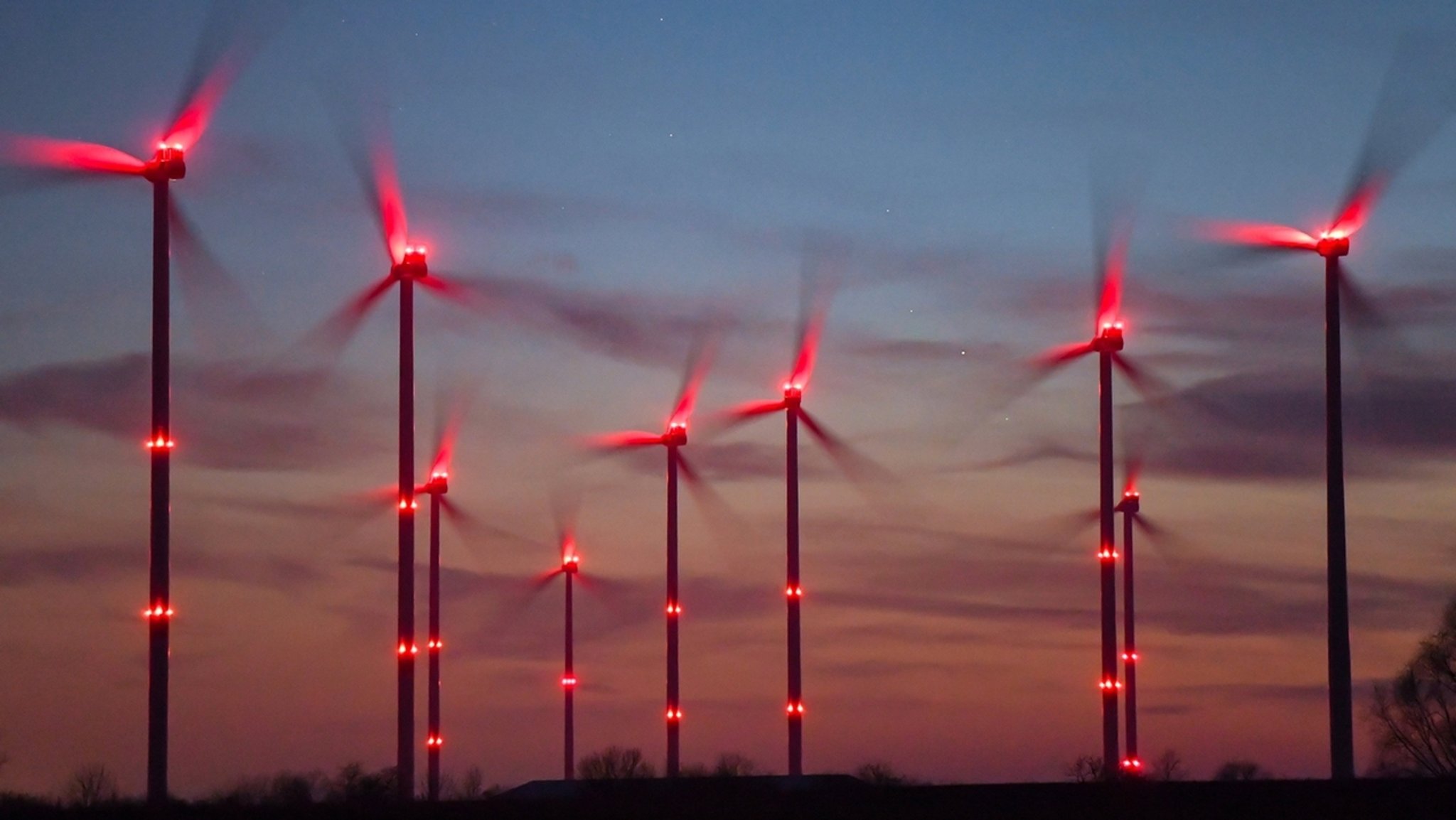 Rotbeleuchtete Windräder in der Nacht