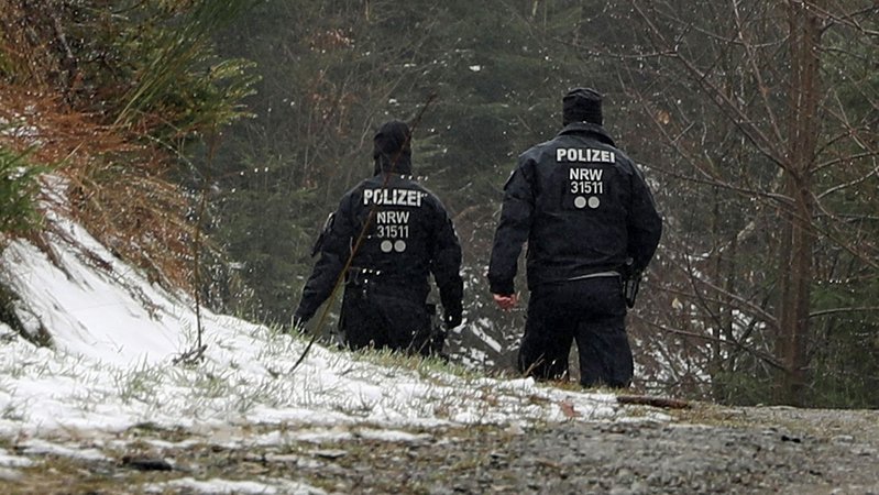 12.03.23, Nähe Freudenberg: Zwei Polizisten stehen in der Nähe des Ortes, an dem die Leiche einer 12-Jährigen gefunden wurde.