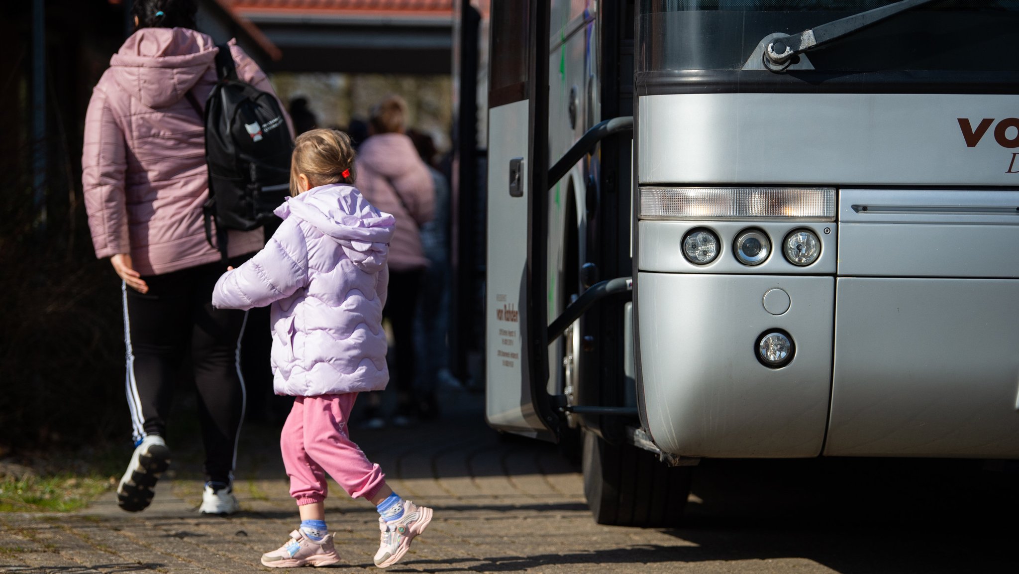 Ukrainische Flüchtlinge steigen an der Flüchtlingsunterkunft aus einem Bus. 