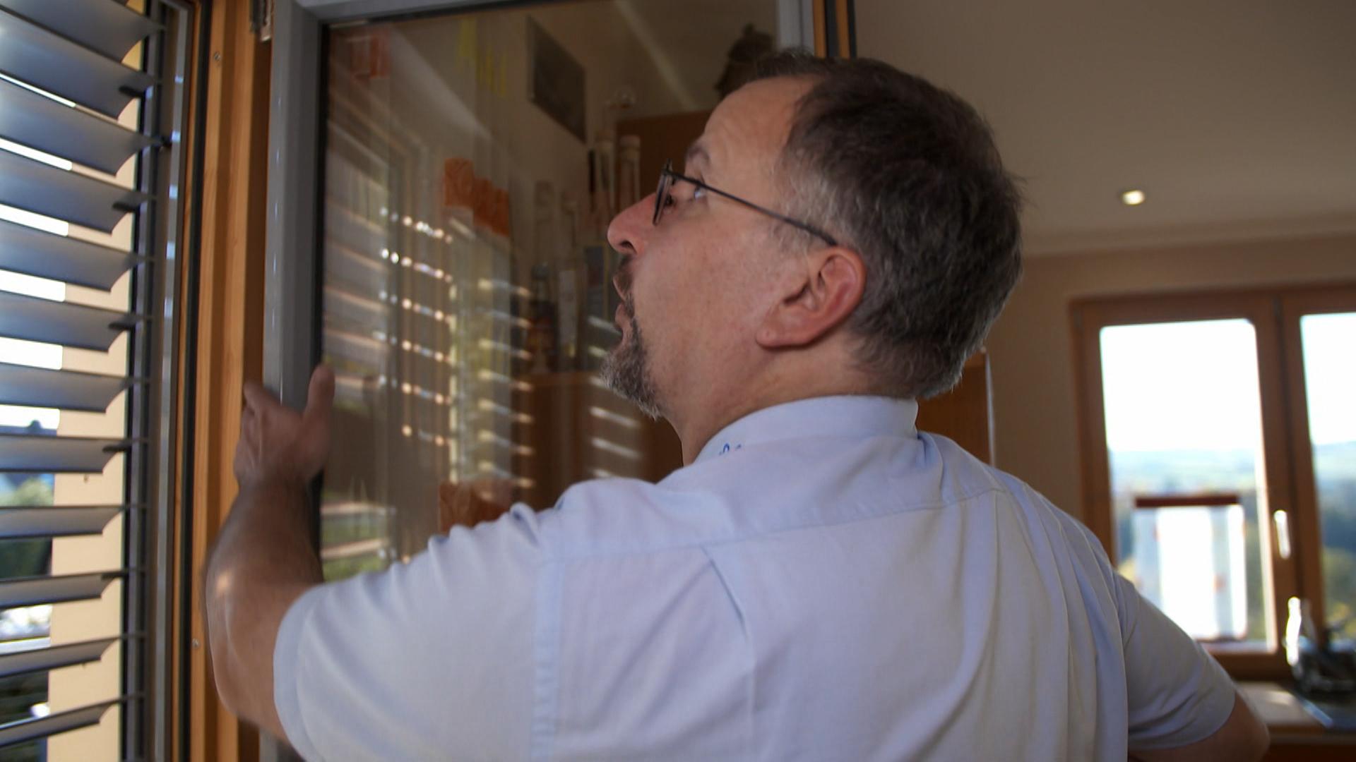 Polizist prüft Fenster in einem Wohnhaus