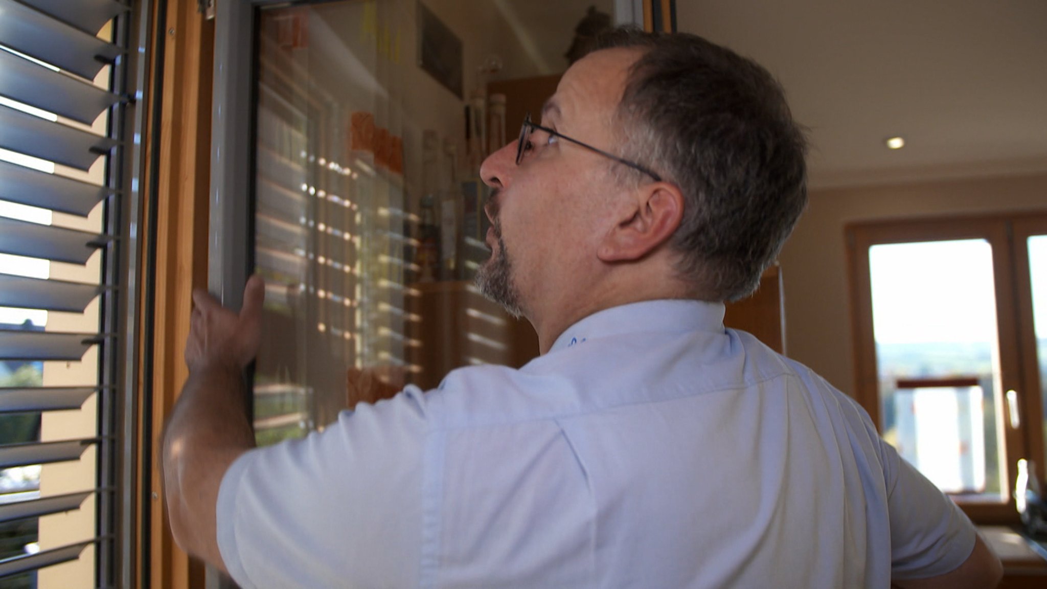 Polizist prüft Fenster in einem Wohnhaus